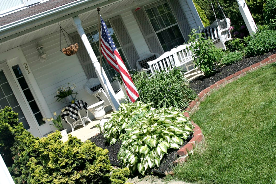 Sprucing up and decorating with accessories, flowers and garden plants getting ready for leisurely  spring and summertime front porch living.