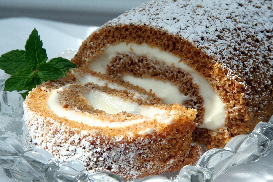 Famous and ever popular Pumpkin Roll. Sweet pumpkin cake with a rich cream cheese filling is a traditional Thanksgiving favorite on the dessert table.