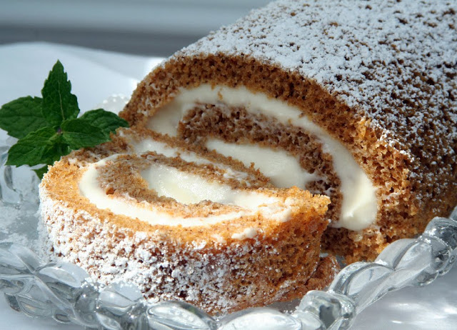 Famous and ever popular Pumpkin Roll. Sweet pumpkin cake with a rich cream cheese filling is a traditional Thanksgiving favorite on the dessert table.