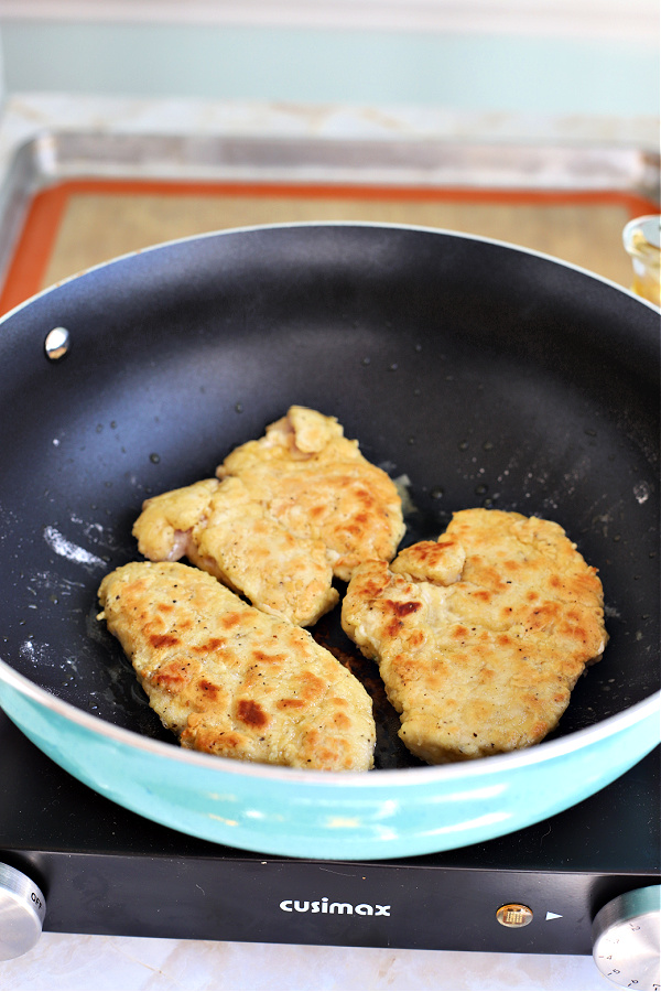 Sautéing chicken breast in skillet for Italian chicken francese.