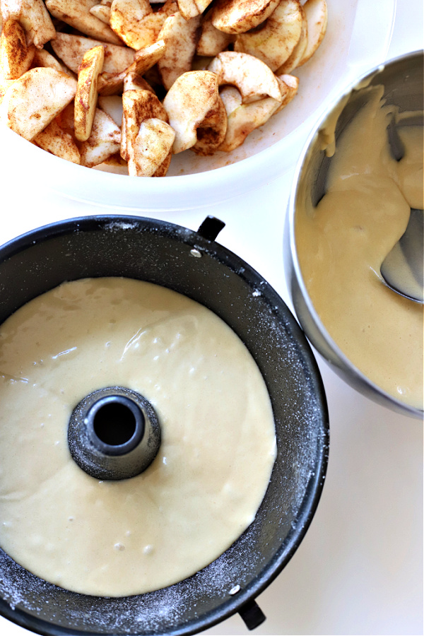 Adding batter to angel food pan for Jewish apple cake