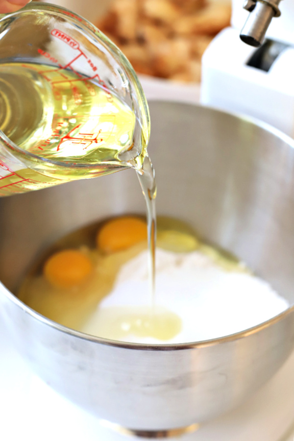 Adding oil, eggs and ingredients to pan for Jewish apple cake