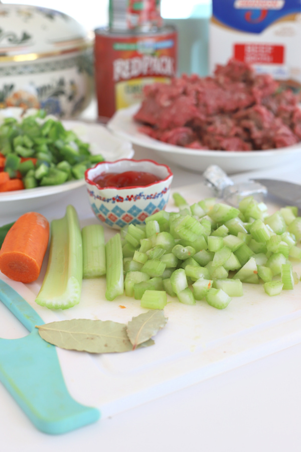 Chopping celery, carrots and onion for hamburger barley vegetable soup.