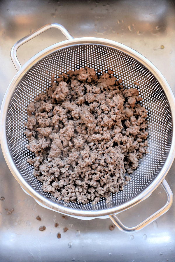 Draining the fat from the ground beef for hamburger barley vegetable soup.