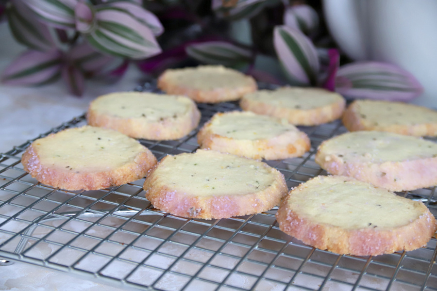 Rolling the sliced lavender shortbread cookie dough in colored sugar for French Sables.