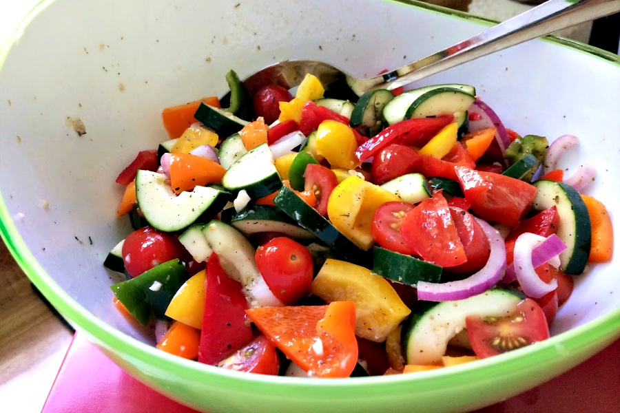 Colorful Greek panzanella salad combines the seasons freshest ingredients with a vibrant and delicious vinaigrette and topped with feta a crispy croutons.