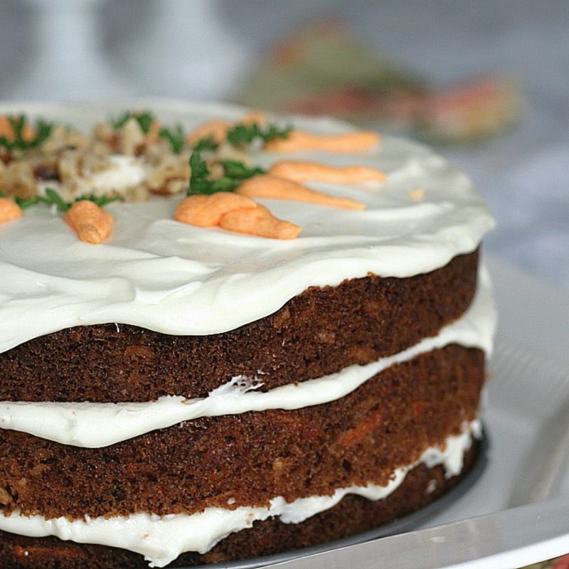 Classic three-layer carrot cake with cream cheese frosting is incredibly moist and delicious! Flecks of carrot, nuts and lightly spiced with cinnamon.