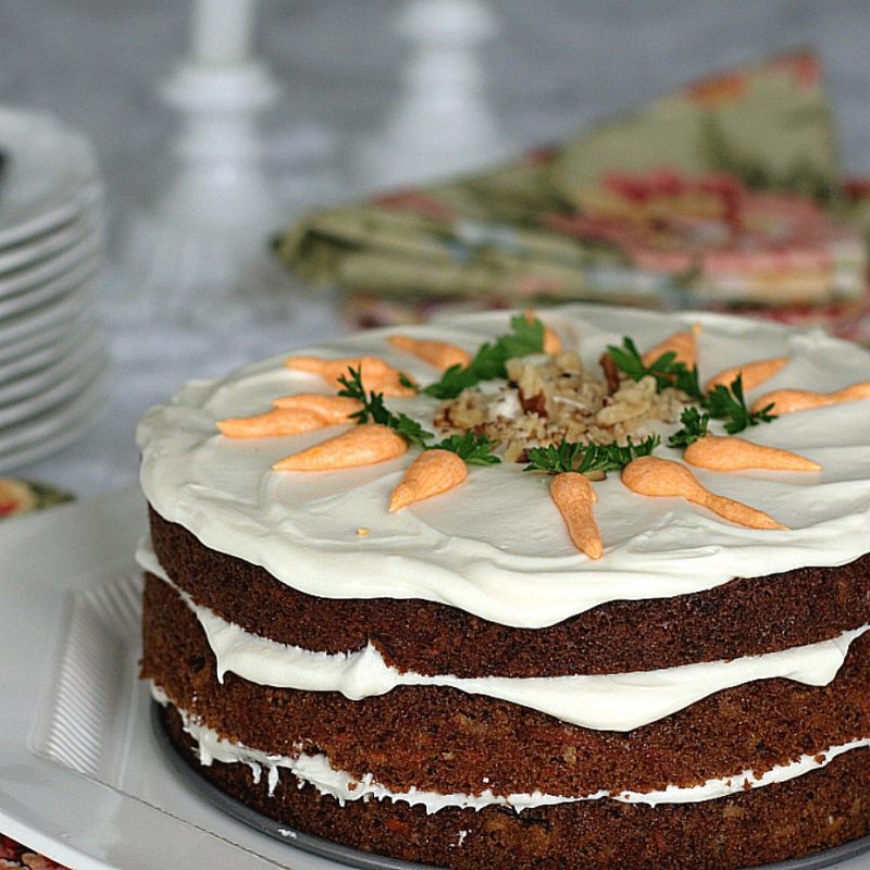 Classic three-layer carrot cake with cream cheese frosting is incredibly moist and delicious! Flecks of carrot, nuts and lightly spiced with cinnamon.