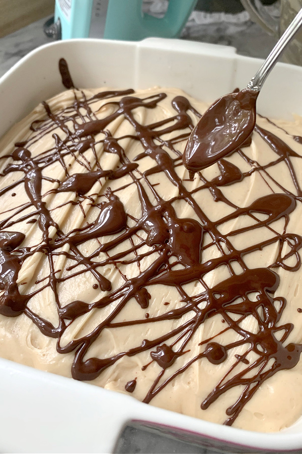 Drizzling melted chocolate onto Peanut Butter Frosted Brownies.