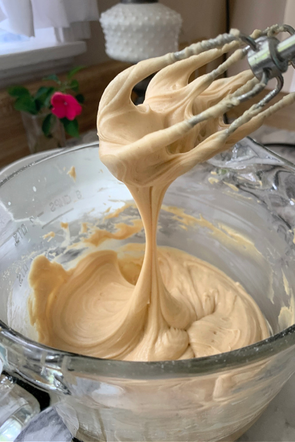 Beating the ingredients together for making Peanut Butter Frosted Brownies recipe.