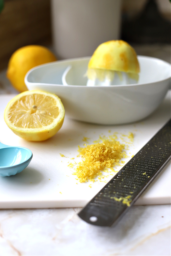 Grating fresh lemon for Triple Lemon Cheesecake.