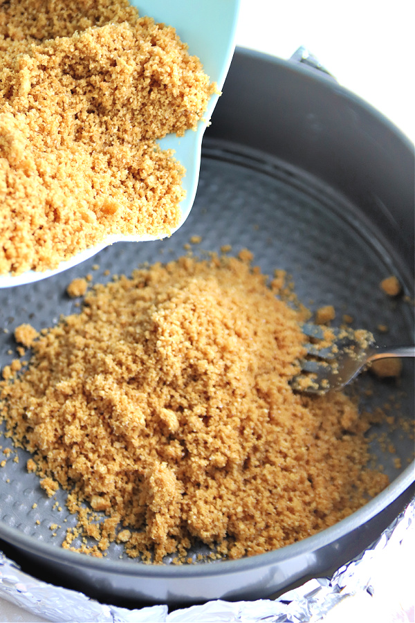 Preparing graham cracker crumb crust for triple lemon cheesecake.