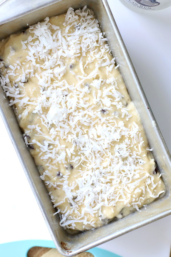 Topping the banana quick bread batter with sweetened flaked coconut before baking.