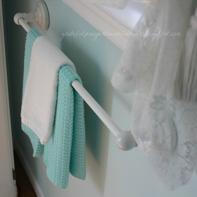 Easy DIY Powder Room redo in Aqua frost paint color with pretty white accents found around the house and re-purposed to create a lovely room on a budget.