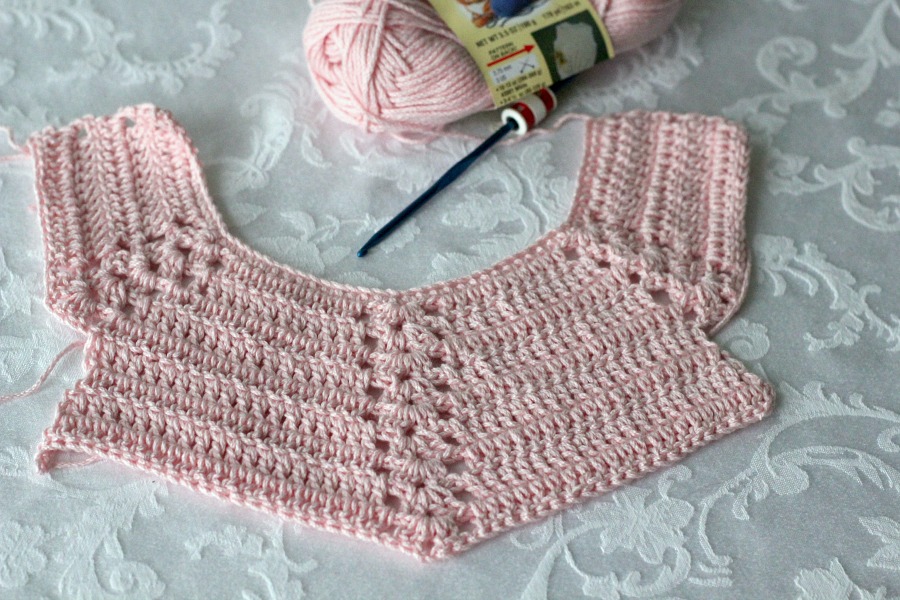 Sweet crochet baby bib is adapted from a vintage pattern and perfect for a toddler. Almost too pretty to use as a bib but adorable to dress up an outfit.