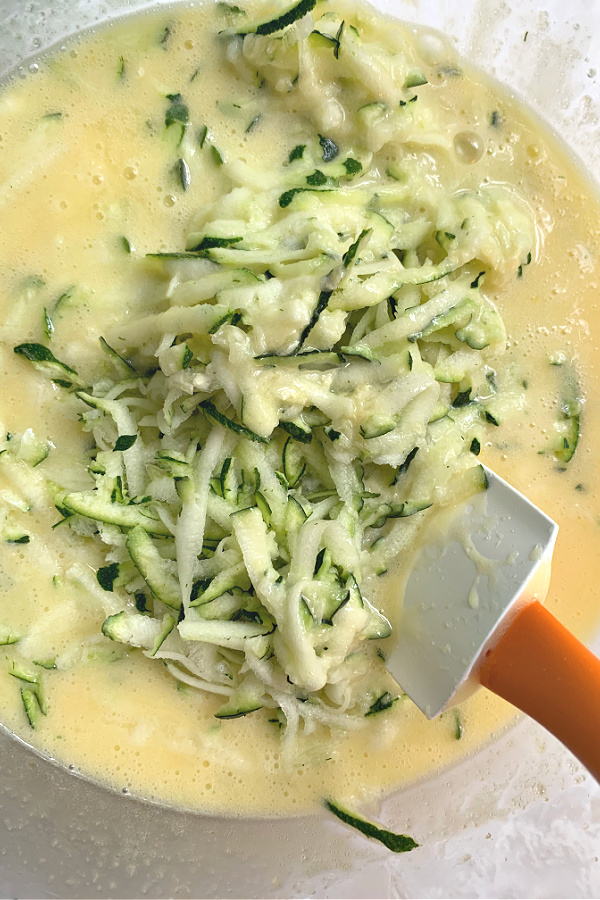 stirring shredded zucchini to the batter