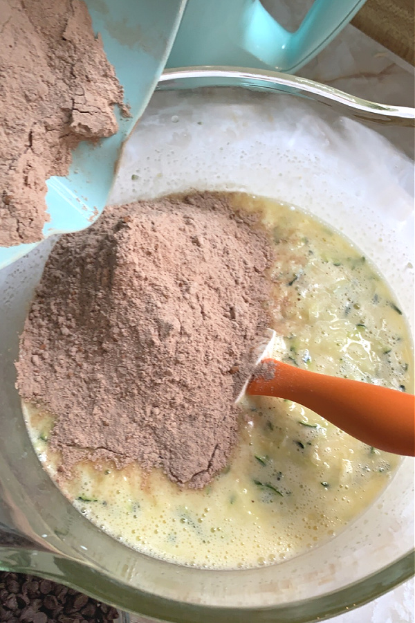 Adding dry ingredients for making the batter for cream cheese chocolate zucchini bread