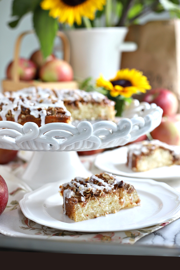 An easy recipe for apple coffee cake with an oat and pecan crumbly topping and a white glaze. It is a lovely autumn dessert or snacking time treat. 