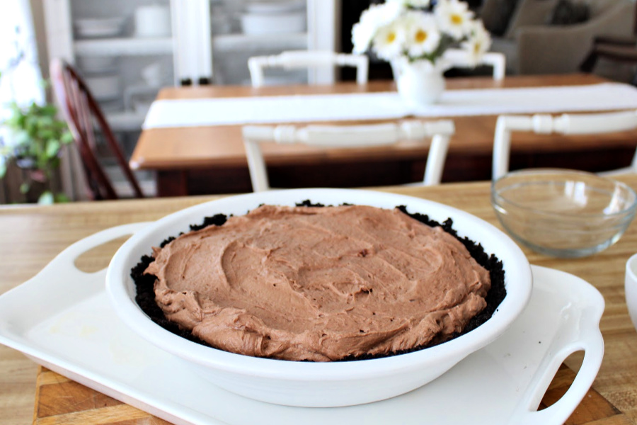 Easy recipe for frozen minty mousse pie with a layers of ice cream, chocolate mousse and whipped cream in a cookie crust is just right for St Patrick's Day