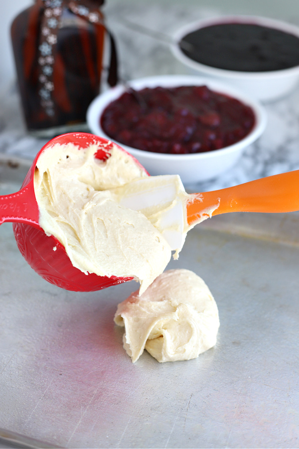 Spooning the batter onto a sheet pan for cherry blueberry fruit bars.