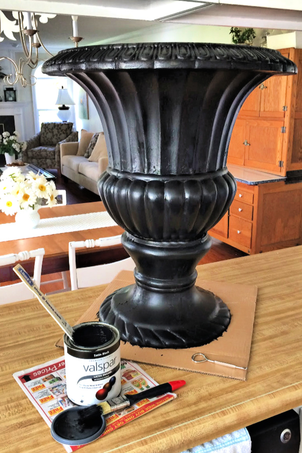 A garage sale urn was a DIY project. A little work and a new coat of paint resulted in a beautiful, farmhouse style porch planter for spring garden flowers with lots of curb appeal. Shade loving annuals flowers and coleus do exceptionally well.