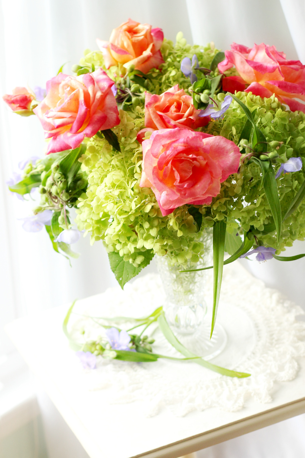 Crystal vase of snowball hydrangea, roses and spiderwort flowers