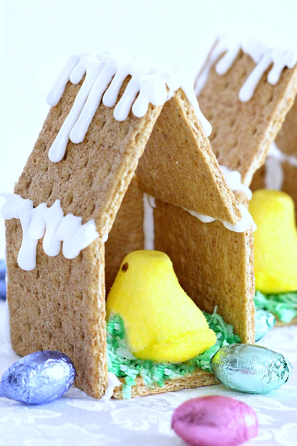 Adorable little Easter Peep Graham Cracker House is so easy to make using royal frosting to glue and assemble coop. Sweet treats for kids and cute table place-setting decorations.