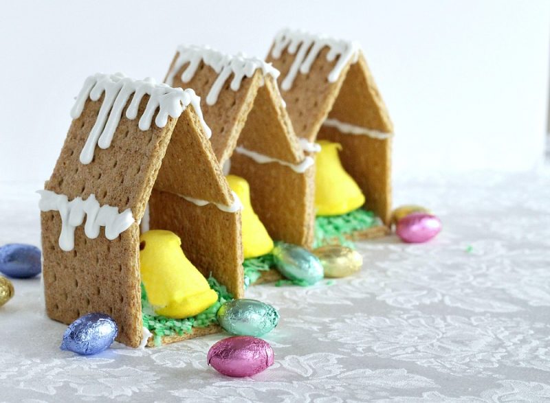 Adorable little Easter Peep Graham Cracker House is so easy to make using royal frosting to glue and assemble coop. Sweet treats for kids and cute table place-setting decorations.