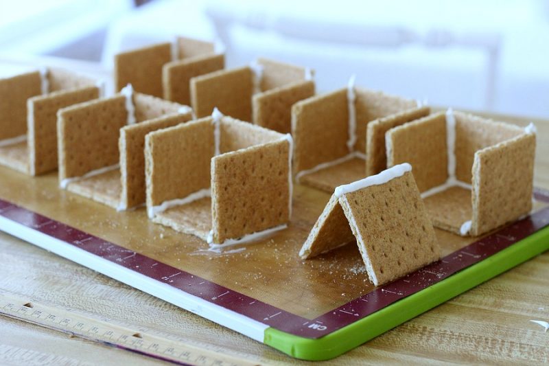 Adorable little Easter Peep Graham Cracker House is so easy to make using royal frosting to glue and assemble coop. Sweet treats for kids and cute table place-setting decorations.