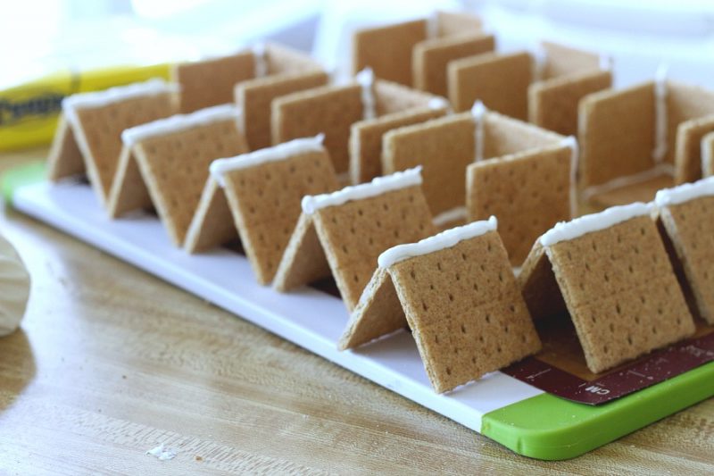 Adorable little Easter Peep Graham Cracker House is so easy to make using royal frosting to glue and assemble coop. Sweet treats for kids and cute table place-setting decorations.