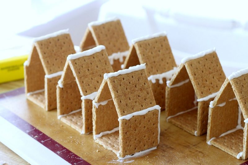 Adorable little Easter Peep Graham Cracker House is so easy to make using royal frosting to glue and assemble coop. Sweet treats for kids and cute table place-setting decorations.