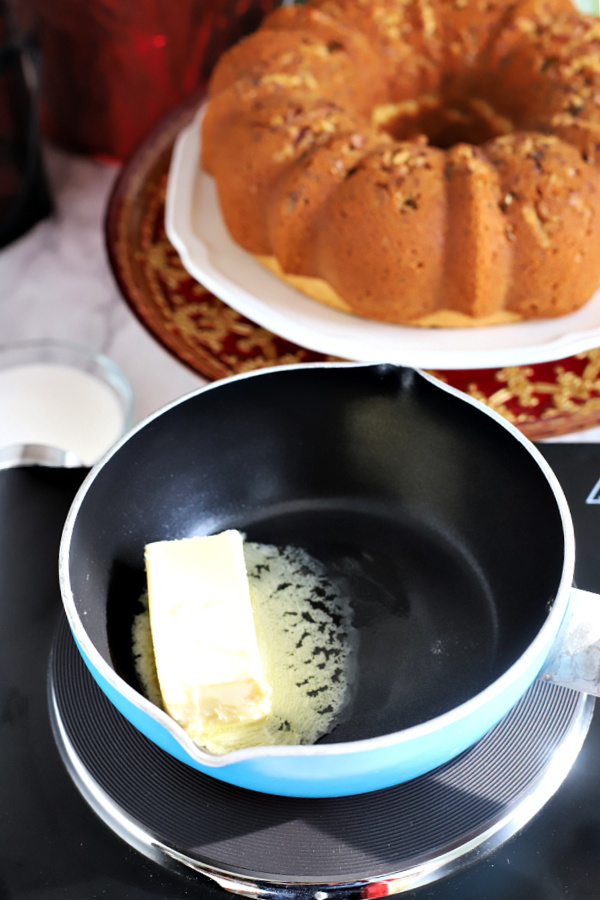 Melting butter to the rum cake glaze.