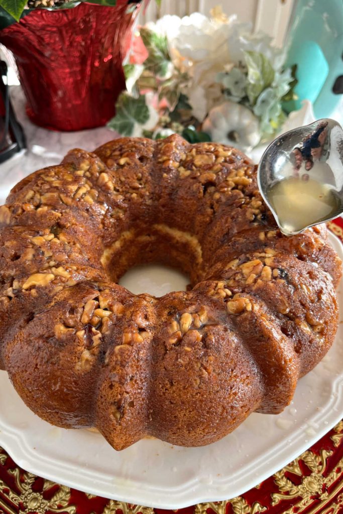 Drizzling the baked rum cake with the buttery rum glaze.