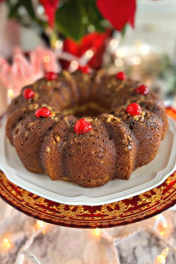 Garnishing the top of the buttery rum cake with maraschino cherries.