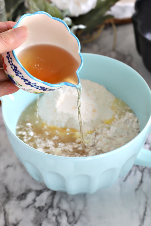 Adding the rum to the cake mix for buttery rum cake.