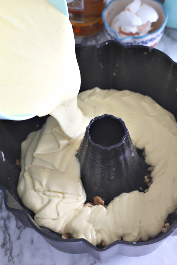 Pouring the mixed batter into the prepared Bundt pan for buttery Rum Cake recipe.