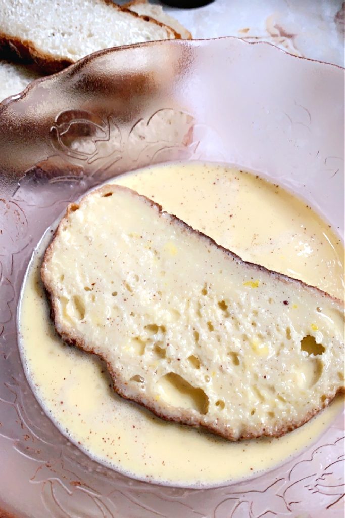 dipping bread into egg mixture for French toast breakfast