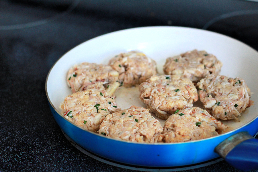 Cooking classic crab cake patties in butter in skillet.