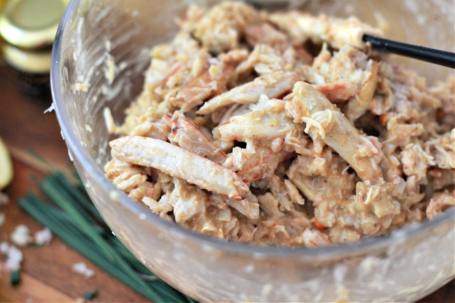 Adding the wet ingredients to crab meat for classic crab cakes recipe.