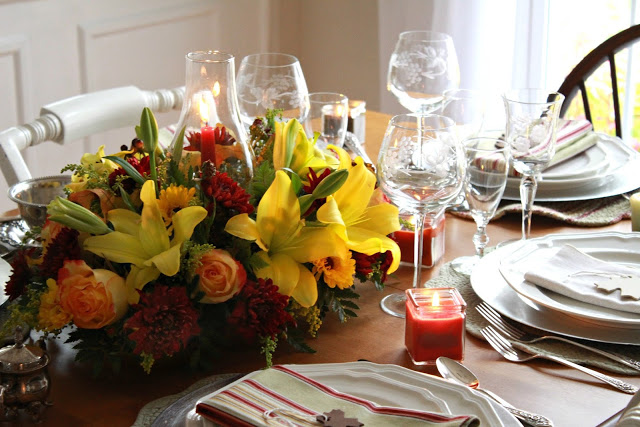 Flowers add a festive touch to your Thanksgiving table. Lovely autumn colors with a hurricane globe & candles creates an elegant tablescape. 