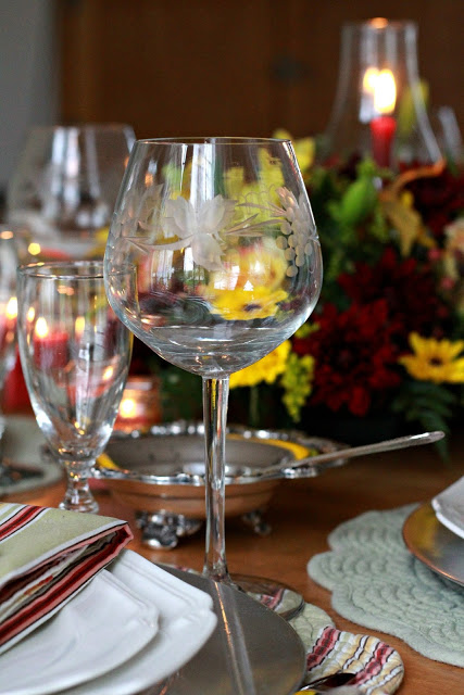 Flowers add a festive touch to your Thanksgiving table. Lovely autumn colors with a hurricane globe & candles creates an elegant tablescape. 