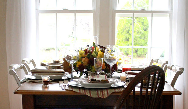 Flowers add a festive touch to your Thanksgiving table. Lovely autumn colors with a hurricane globe & candles creates an elegant tablescape. 