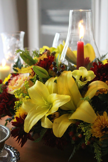 Flowers add a festive touch to your Thanksgiving table. Lovely autumn colors with a hurricane globe & candles creates an elegant tablescape. 