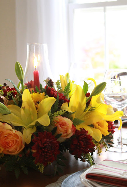 Flowers add a festive touch to your Thanksgiving table. Lovely autumn colors with a hurricane globe & candles creates an elegant tablescape. 