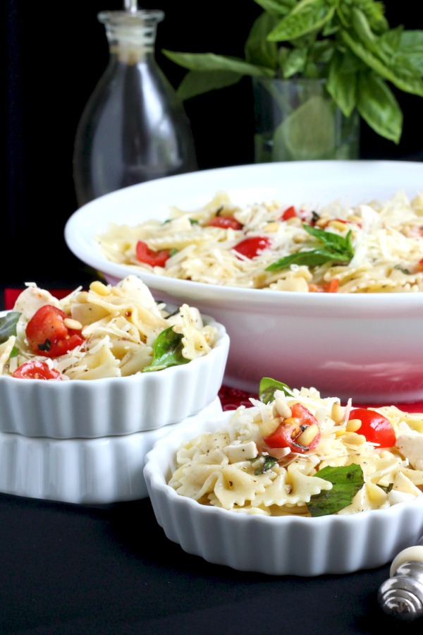 Easy recipe for Caprese Bow Tie Pasta Salad served cold with fresh mozzarella cheese, tomatoes and basil. Perfect for summertime dining.