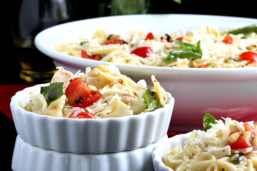 Easy recipe for Caprese Bow Tie Pasta Salad served cold with fresh mozzarella cheese, tomatoes and basil. Perfect for summertime dining.