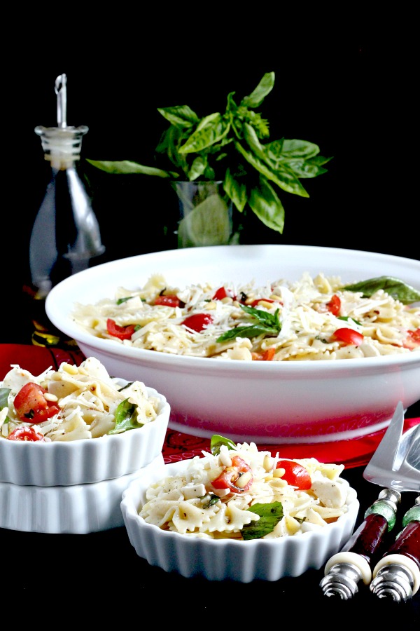 Easy recipe for Caprese Bow Tie Pasta Salad served cold with fresh mozzarella cheese, tomatoes and basil. Perfect for summertime dining.