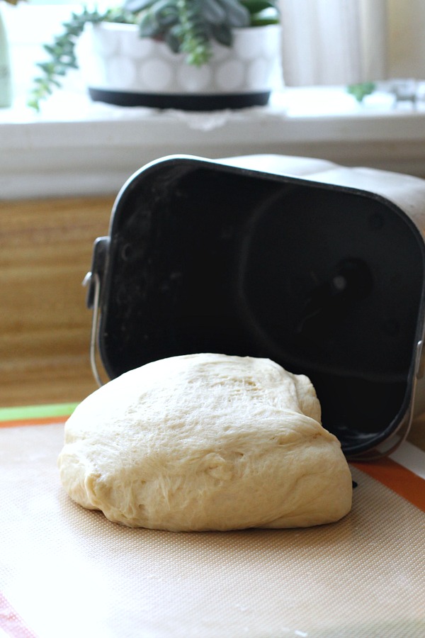 Bake a festive loaf of rich holiday brioche from easy recipe using a bread machine. Frosted with a white glaze and colorful sprinkles. Great food gift idea.