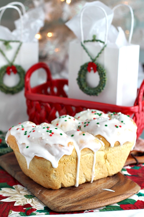 Bake a festive loaf of rich holiday brioche from easy recipe using a bread machine. Frosted with a white glaze and colorful sprinkles. Great food gift idea.