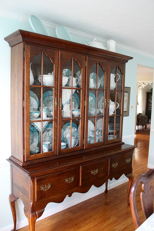 Dining room china cabinet with teal dinnerware dishes from 222 Fifth aqua and teal peacock pattern.